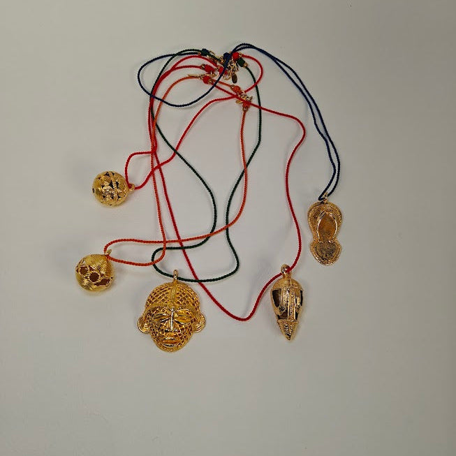 Gold necklaces with various pendants on a light gray background