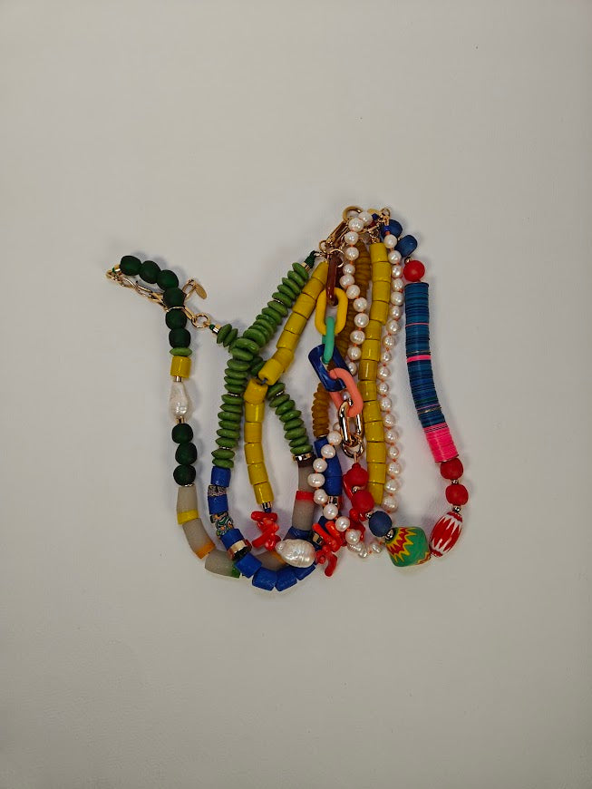 Colorful beaded necklaces on a plain background