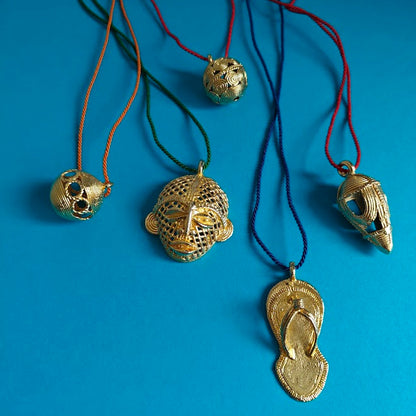 Gold necklaces with unique pendants on a blue background