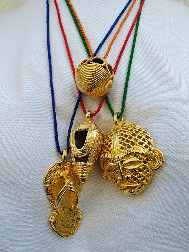Four gold African pendant necklaces  on a white background