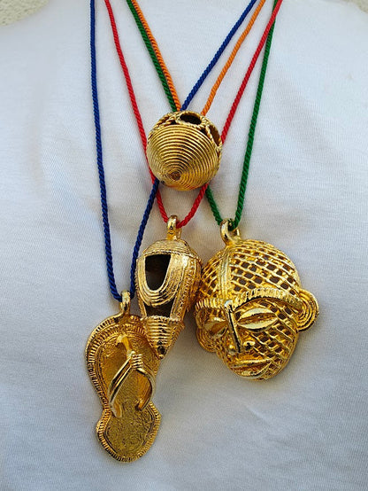 Four gold African pendant necklaces  on a white background