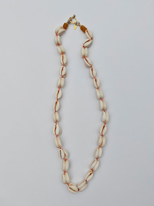 Long length cowrie shell and glass bead necklace on a white background
