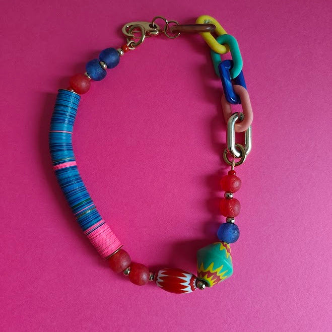 Colorful beaded necklace on a pink background
