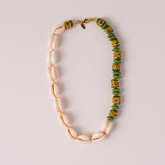 Necklace with cowrie shells and green floral design recycled glass beads  on a light gray background