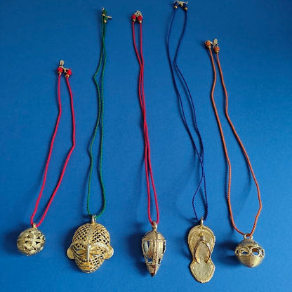 Five brass gold necklaces with various pendants on a blue background