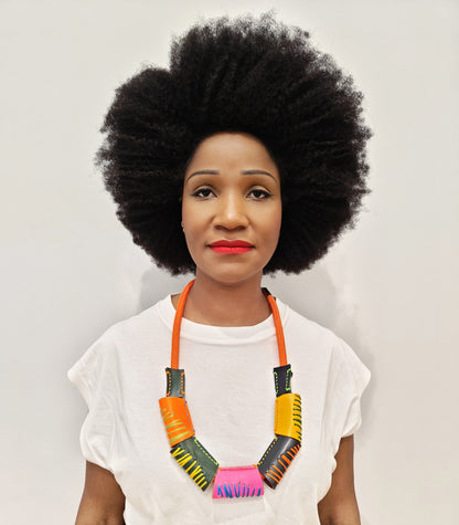 Woman wearing a handcrafted colorful leaather bead necklace against a plain background