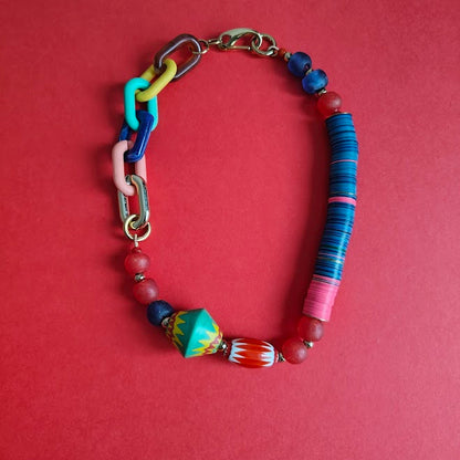 Colorful beaded necklace with  gold metal clasp on a red background
