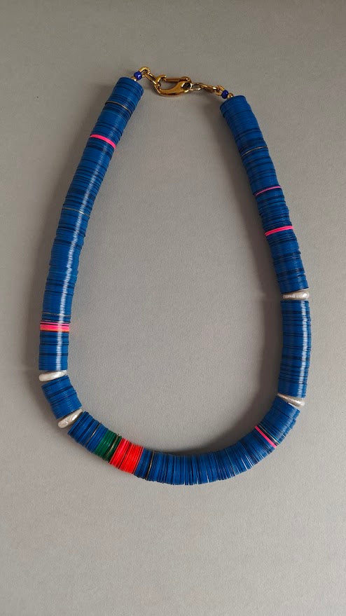 Necklace with blue beads on a gray background