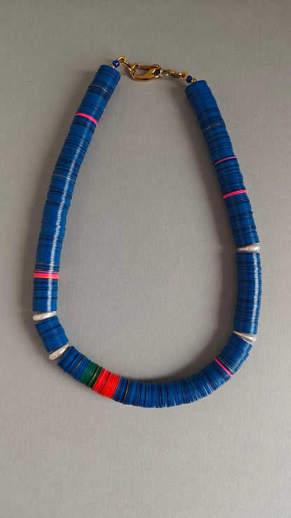 Necklace with blue beads on a gray background