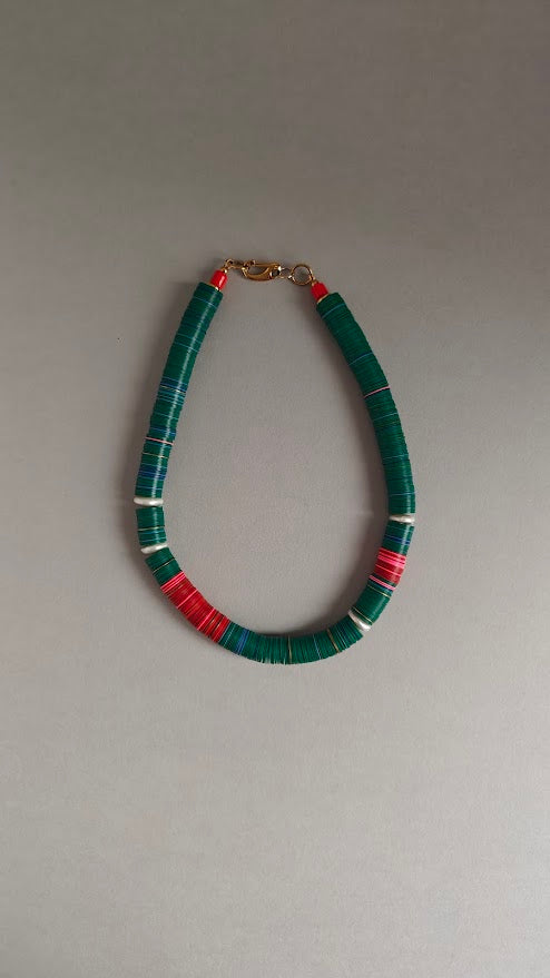 Necklace with green, red, pink beads and freshwater pearls on a gray background