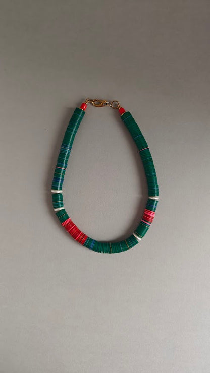 Necklace with green, red, pink beads and freshwater pearls on a gray background