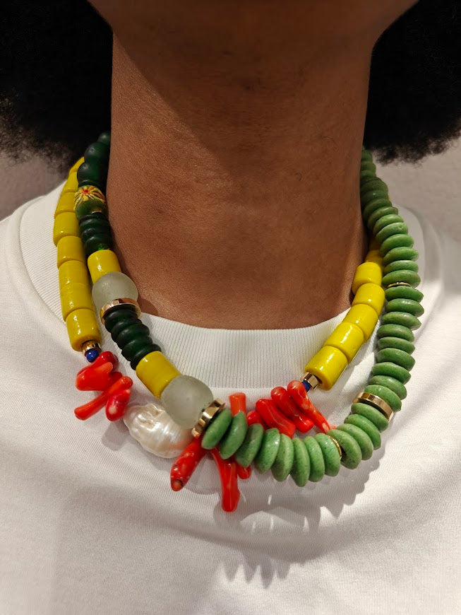 Two colorful beaded necklace layered together, worn by model with a white tee shirt.