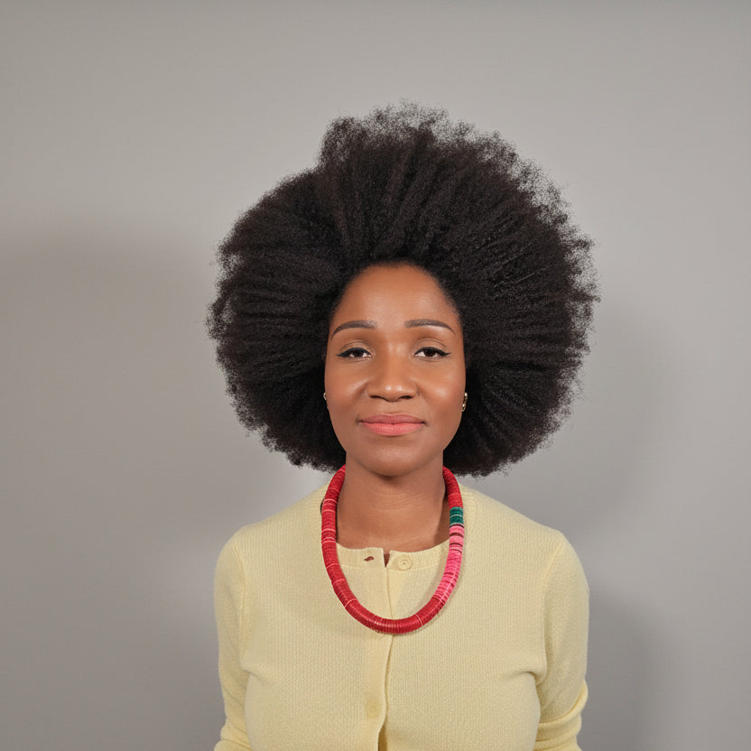 Woman wearing a yellow cardigan with a colour block red, wine, pink and green   necklace against a white wall