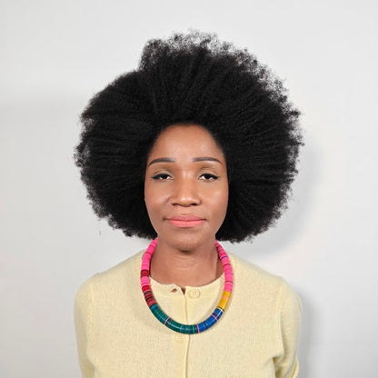 Woman wearing a colorful necklace against a plain background