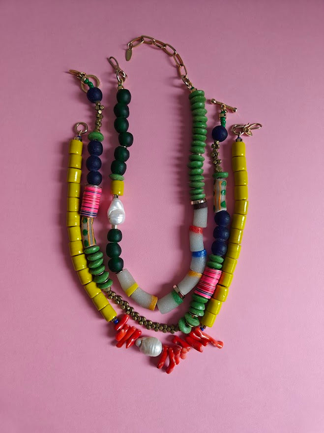 Three colorful beaded necklace on a pink background