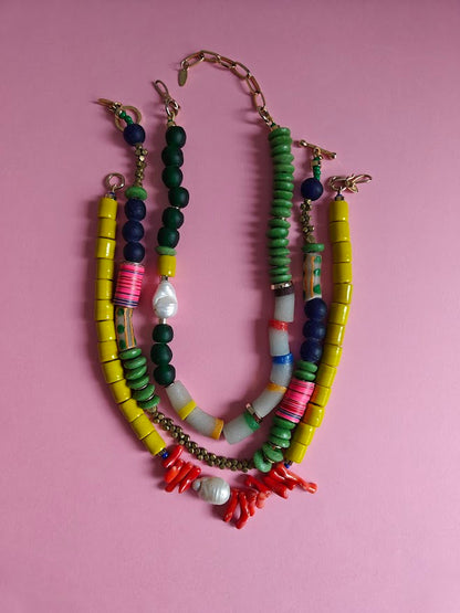 Three colorful beaded necklace on a pink background