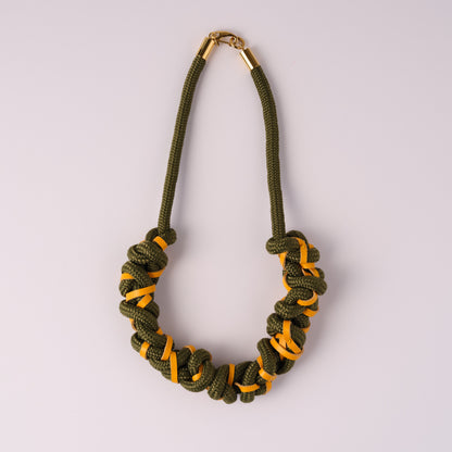 Khaki green rope and yellow leather necklace on white background