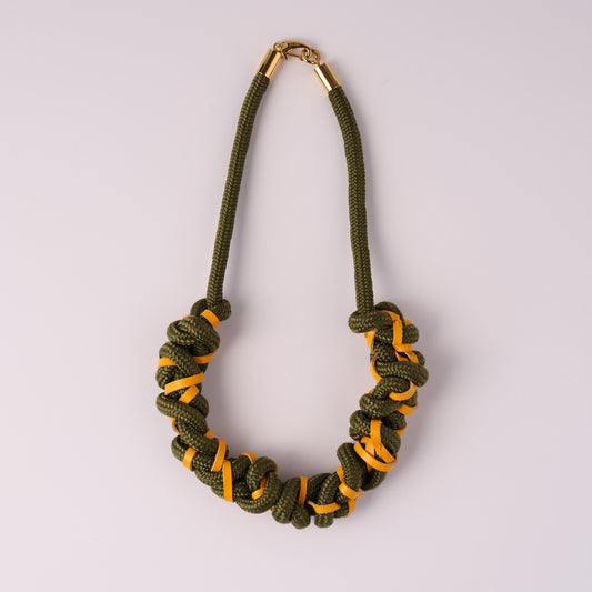Khaki green rope and yellow leather necklace on white background